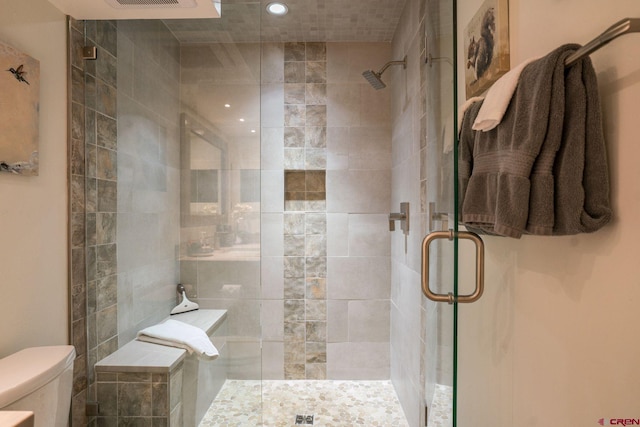 bathroom featuring an enclosed shower and toilet