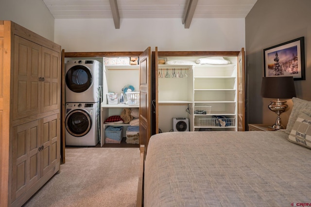 bedroom with stacked washing maching and dryer, light colored carpet, and beam ceiling