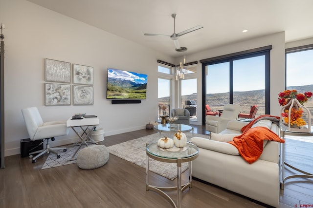 living room with dark wood-type flooring and ceiling fan with notable chandelier