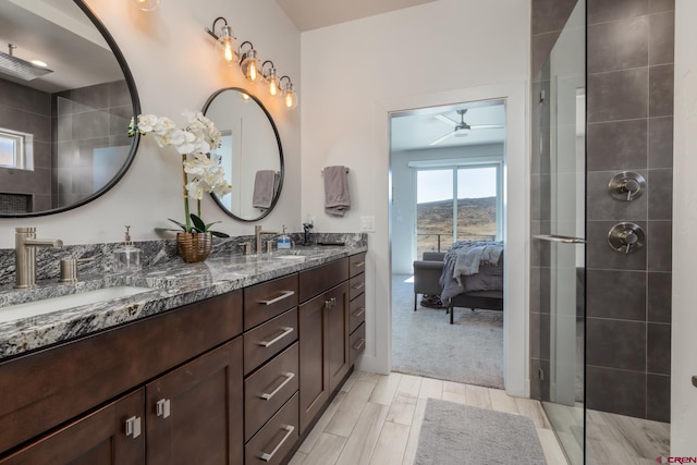 bathroom with ceiling fan, vanity, and tiled shower