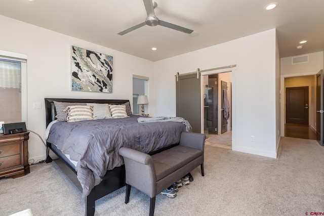 bedroom featuring a barn door, ceiling fan, and light colored carpet