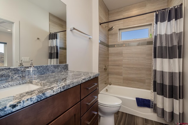 full bathroom featuring shower / bath combo, plenty of natural light, vanity, and toilet