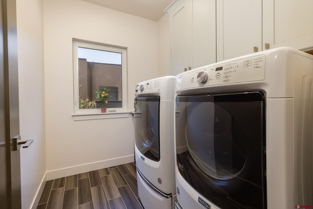 washroom with washer and clothes dryer, cabinets, and dark hardwood / wood-style floors