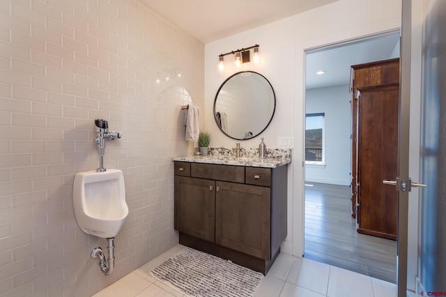 bathroom with tile walls, vanity, and hardwood / wood-style flooring