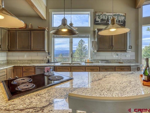 kitchen featuring dishwasher, backsplash, a wealth of natural light, and beamed ceiling