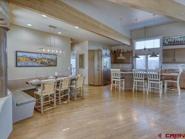 kitchen with beamed ceiling, stainless steel refrigerator with ice dispenser, decorative backsplash, and light wood-type flooring