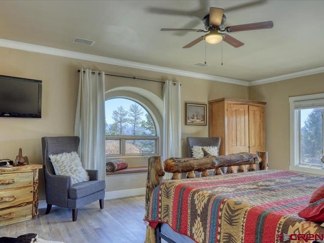 bedroom featuring crown molding, light wood-type flooring, multiple windows, and ceiling fan