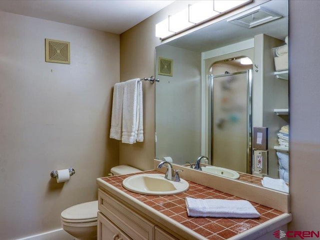 bathroom with walk in shower, vanity, and toilet