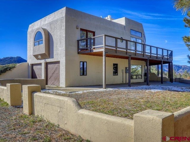 view of front of house featuring a balcony and a patio area