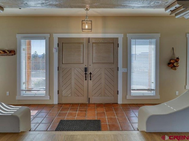 tiled entryway with a textured ceiling