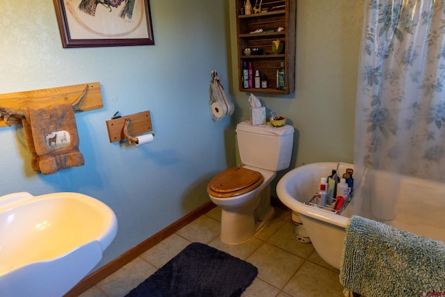 bathroom with toilet, sink, and tile patterned floors