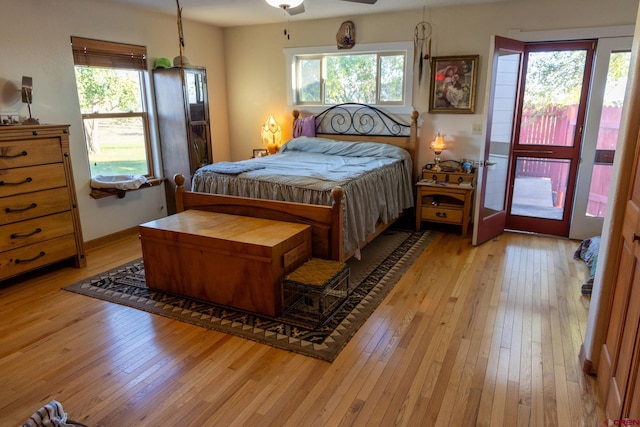 bedroom featuring ceiling fan, multiple windows, and light hardwood / wood-style flooring