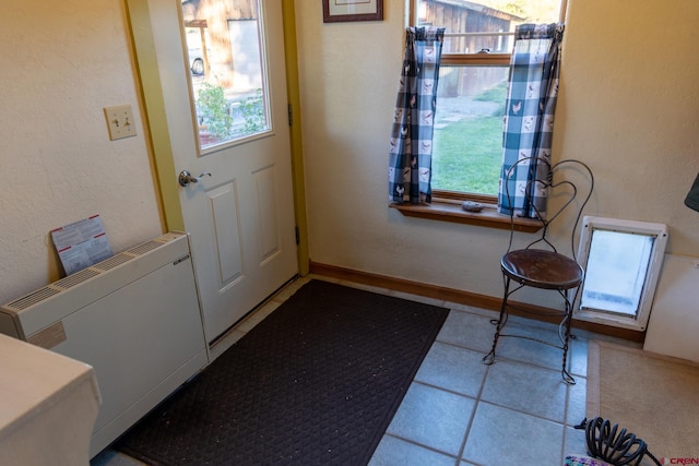 doorway to outside with light tile patterned floors and plenty of natural light