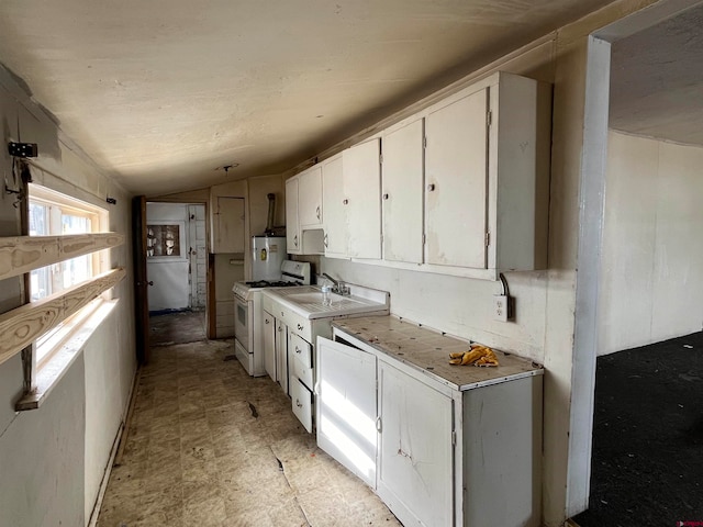 kitchen featuring white cabinetry, sink, white gas range oven, lofted ceiling, and water heater