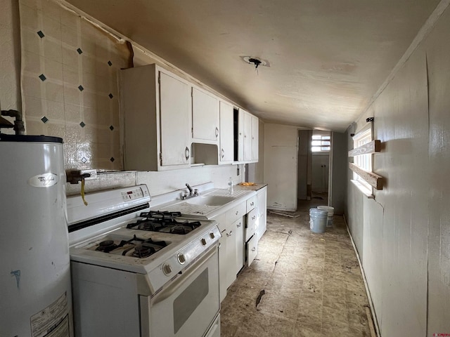 kitchen with white cabinetry, sink, vaulted ceiling, gas water heater, and white gas stove