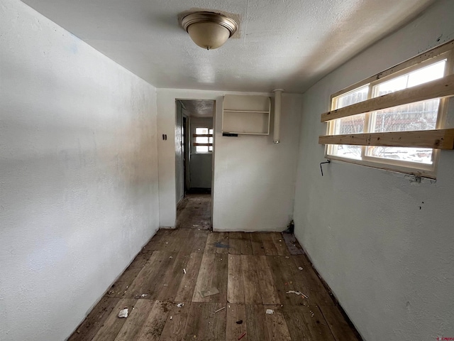 hallway featuring dark hardwood / wood-style flooring and a textured ceiling