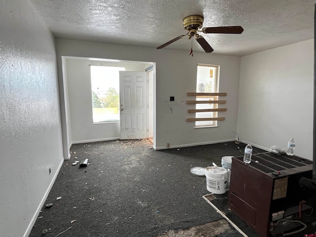 empty room featuring a textured ceiling, a healthy amount of sunlight, and ceiling fan