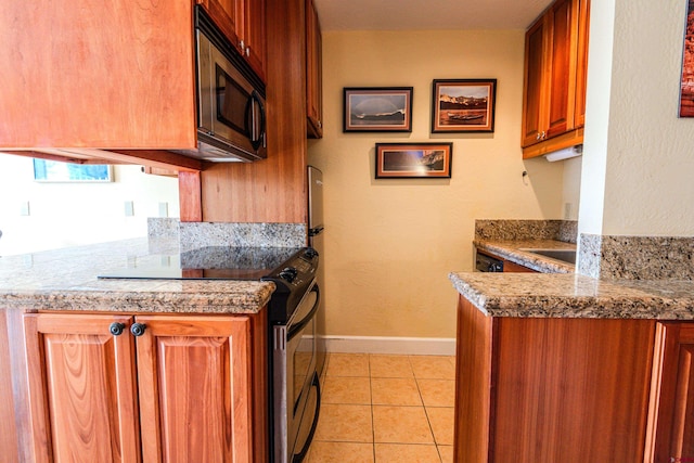 350 Country Club Dr Unit 116A, Crested Butte, CO 81224 - kitchen featuring appliances with stainless steel finishes, baseboards, brown cabinetry, light tile patterned floors, and a peninsula
