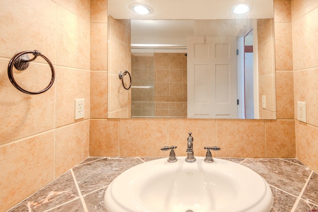 bathroom with tile walls and sink