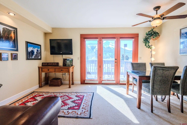 carpeted living room with french doors and ceiling fan