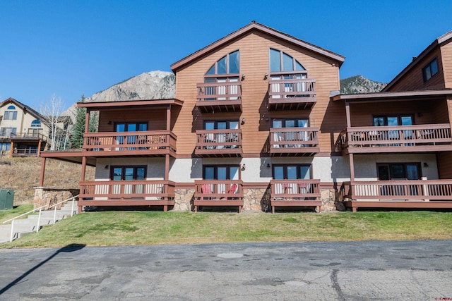 350 Country Club Dr Unit 116A, Crested Butte, CO 81224 - back of property with a balcony, stucco siding, and a mountain view