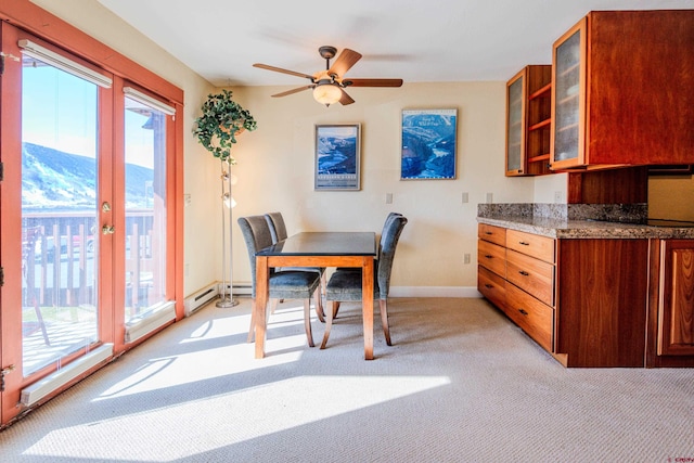 dining area featuring a mountain view, light carpet, and ceiling fan