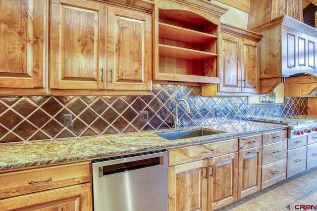 kitchen with light stone counters, sink, tasteful backsplash, light tile patterned floors, and appliances with stainless steel finishes