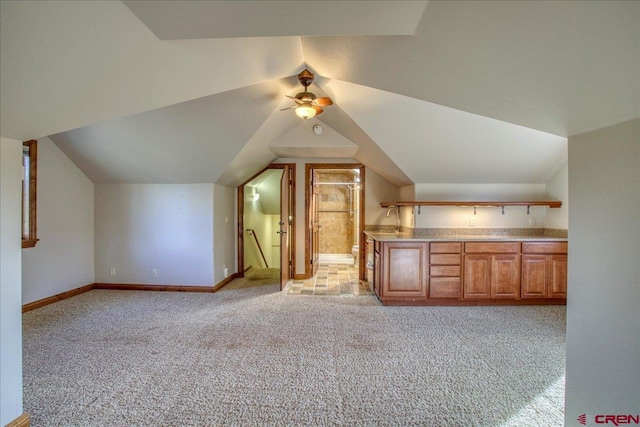 bonus room with vaulted ceiling, light colored carpet, and ceiling fan