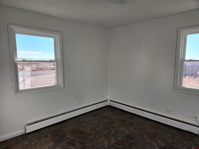 spare room featuring a textured ceiling and a baseboard heating unit