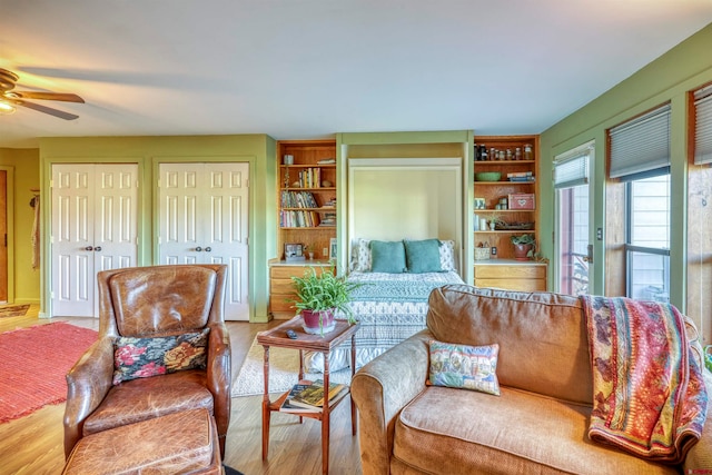 living area with ceiling fan and light hardwood / wood-style flooring