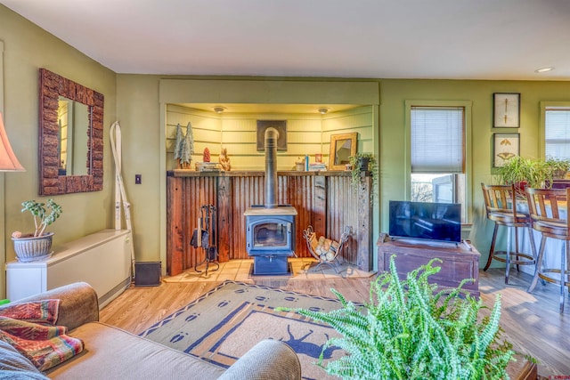 living room with a wood stove and light wood-type flooring