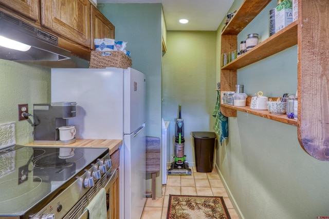 kitchen with stainless steel electric stove and light tile patterned floors