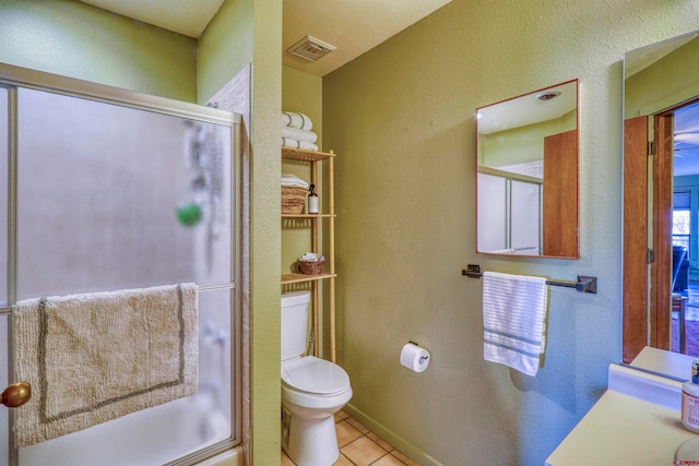 bathroom with shower / bath combination with glass door, tile patterned flooring, and toilet