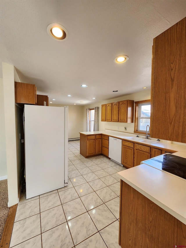 kitchen with sink, kitchen peninsula, light tile patterned floors, white appliances, and a baseboard radiator