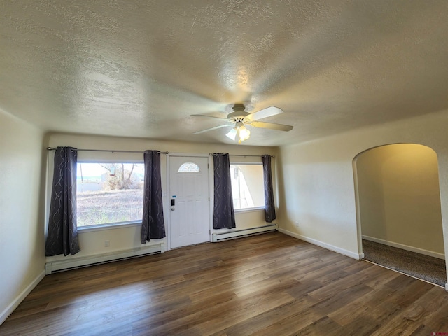 foyer featuring ceiling fan, a textured ceiling, dark hardwood / wood-style floors, and a baseboard heating unit