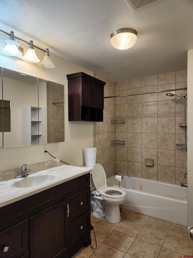 full bathroom with a textured ceiling, tile patterned floors, tiled shower / bath, and toilet