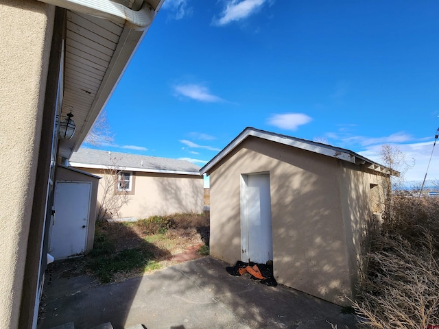 exterior space with a storage shed and a patio area