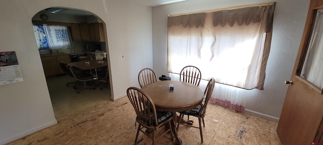 9966 Rd 7, Dove Creek, CO 81324 - dining room with arched walkways, healthy amount of natural light, baseboards, and an office area