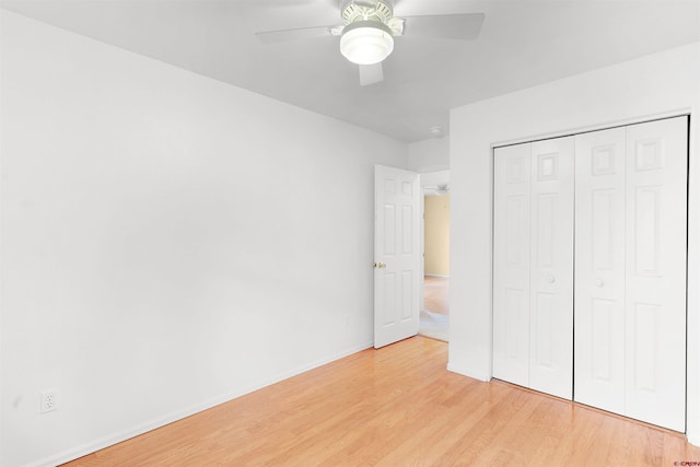 unfurnished bedroom with light hardwood / wood-style flooring, ceiling fan, and a closet