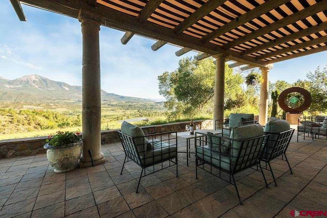 view of patio / terrace with a pergola and a mountain view