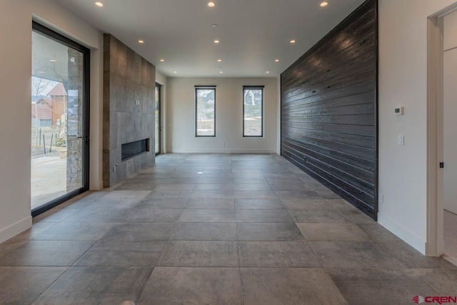 77 Coyote Ridge Rd, Crested Butte, CO 81224 - unfurnished living room featuring recessed lighting, baseboards, a tiled fireplace, and an accent wall