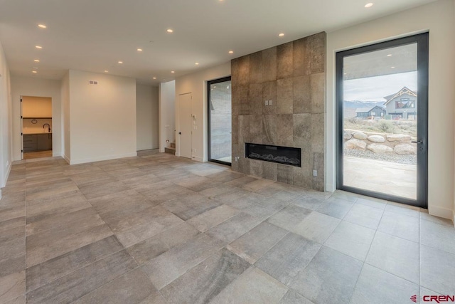 77 Coyote Ridge Rd, Crested Butte, CO 81224 - unfurnished living room featuring visible vents, light tile patterned flooring, baseboards, recessed lighting, and a tile fireplace