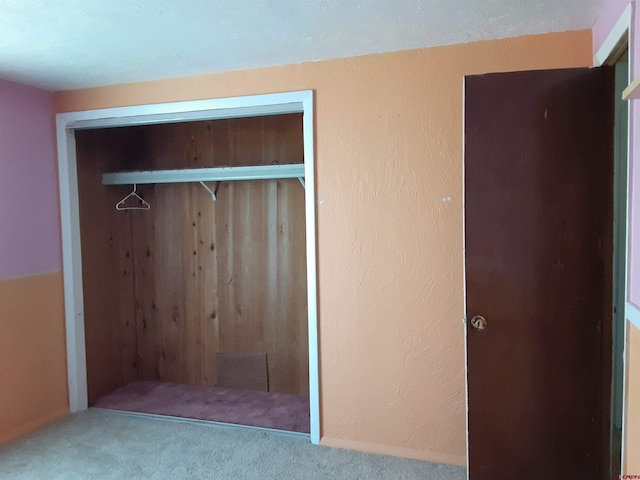 unfurnished bedroom featuring carpet flooring and a closet