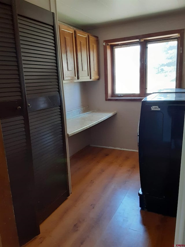 laundry room featuring light hardwood / wood-style floors, cabinets, and washer / dryer