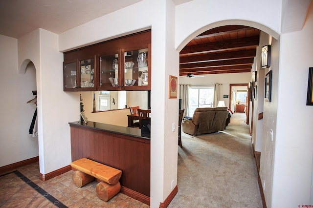 interior space featuring beamed ceiling, wood ceiling, and carpet