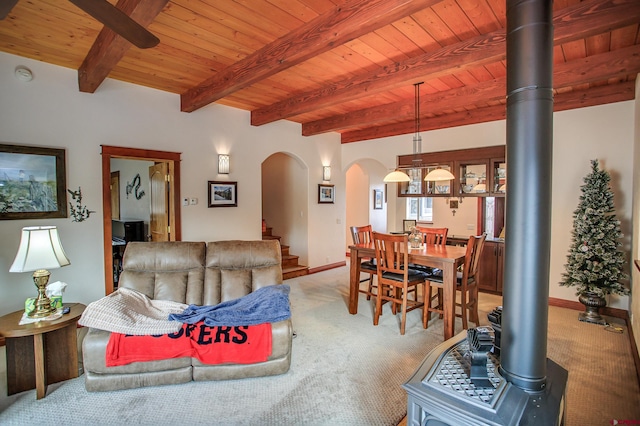 carpeted living room featuring beamed ceiling and wood ceiling