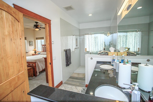 bathroom featuring a shower, hardwood / wood-style flooring, ceiling fan, and vanity