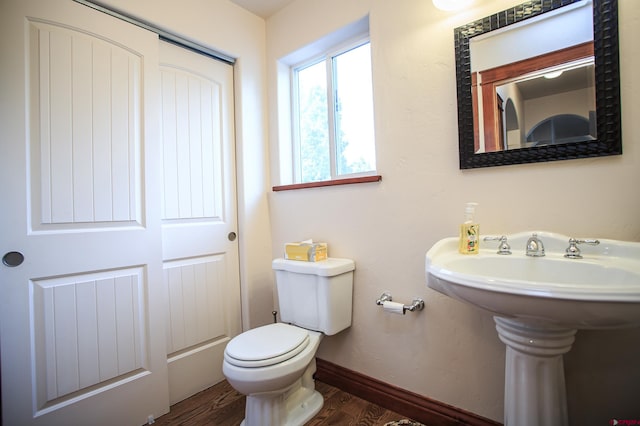 bathroom featuring hardwood / wood-style flooring, toilet, and sink