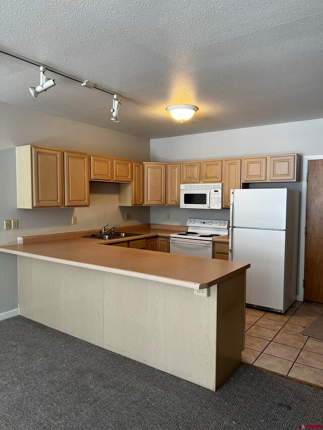 kitchen featuring sink, track lighting, kitchen peninsula, white appliances, and light colored carpet