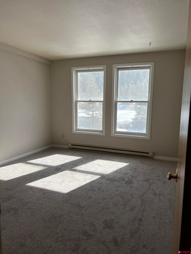 carpeted empty room featuring a baseboard radiator and a textured ceiling